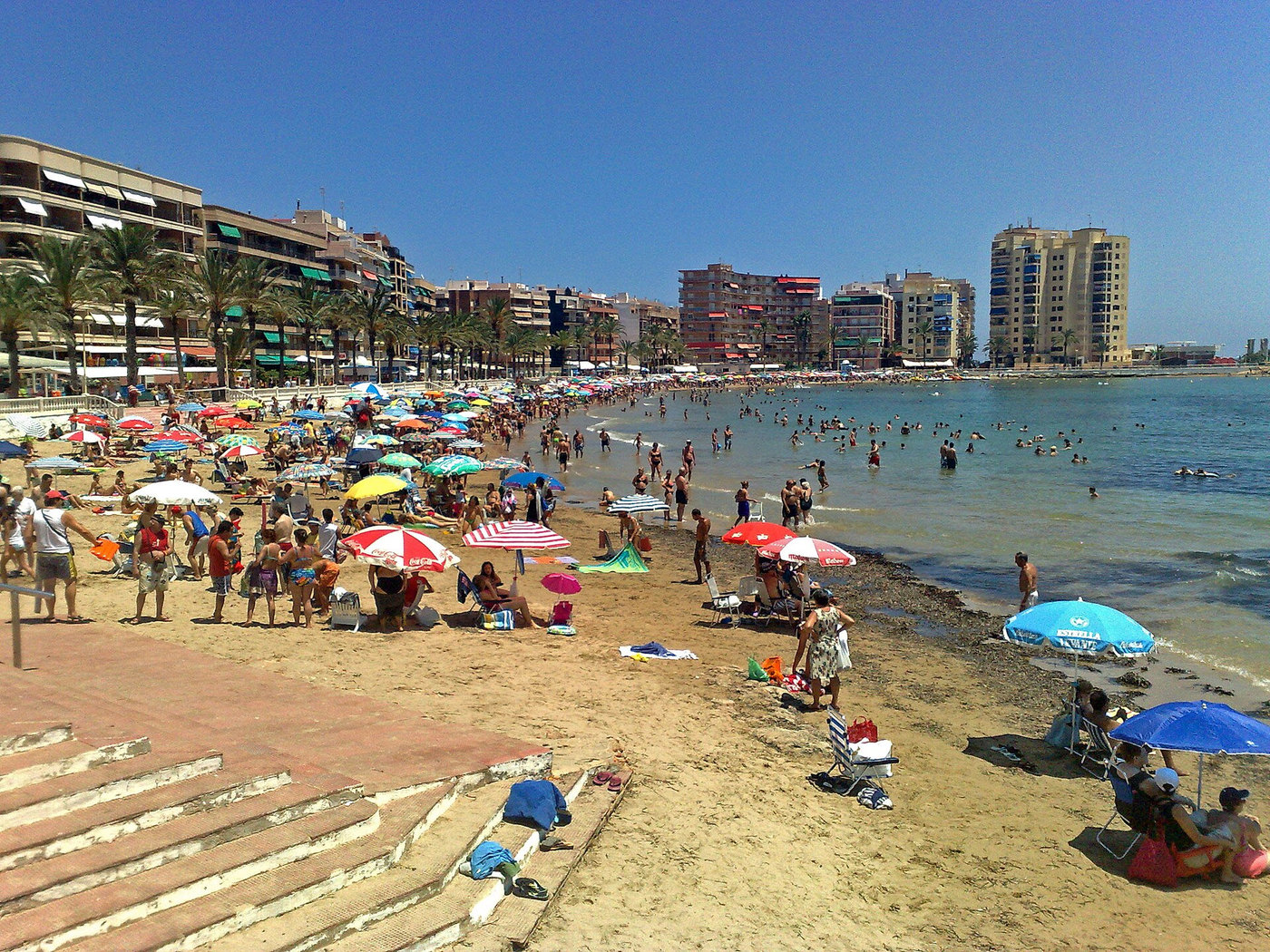 Torreviejan ranta, uimareita ja aurinkovarjoja